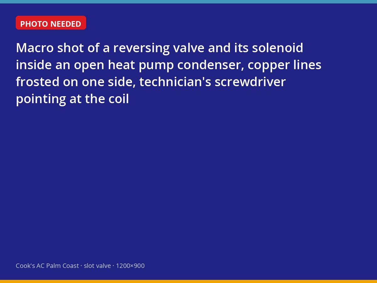 Reversing valve inside a heat pump outdoor unit being inspected by a technician